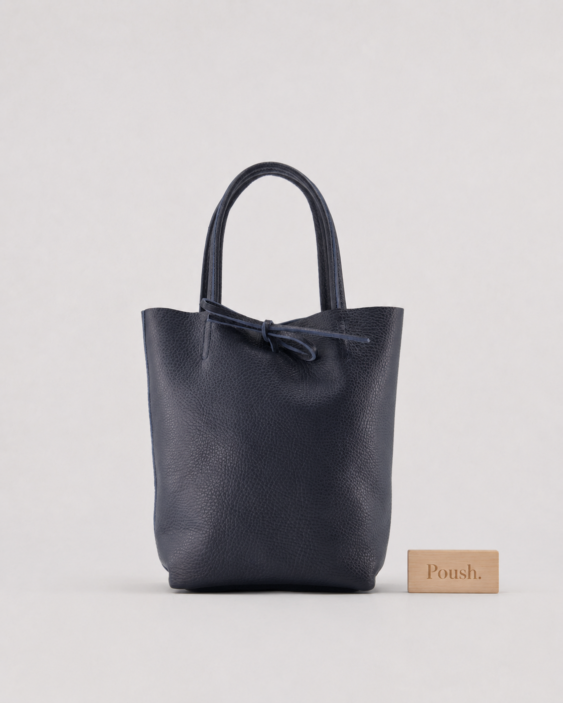 Donkerblauwe Alice mini shopper van generfd rundleer met korte handvatten en leren touwsluiting.