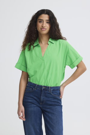 Groene blouse gecombineerd met denim jeans