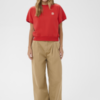 Rood boxy dames sweatshirt met korte mouwen, ronde hals en ribboord gecombineerd met beige pantalon.