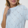 Lichtblauwe opengewerkte knit top met korte mouwen en ribboorden, casual gedragen op denim voor een frisse zomerse look.