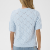 Lichtblauwe opengewerkte knit top met korte mouwen en ribboorden, casual gedragen op denim voor een frisse zomerse look.