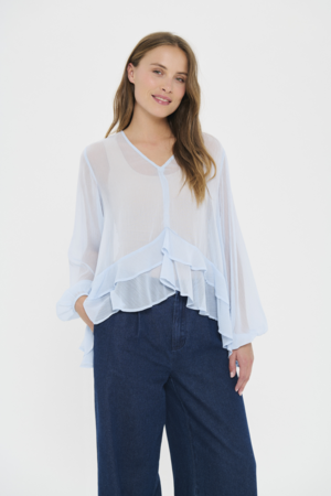Lichtblauwe Saint Tropez blouse met ruffles en V-hals gedragen op een wijde jeans in een luchtige look