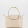 Ecru leren handtas met goudkleurige details en korte hengsels in een tijdloos design