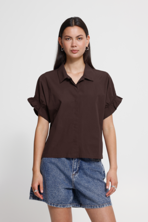 ICHI blouse met ruffle mouwen en boxy pasvorm in de kleur Chicory Coffee. Gedragen op een korte jeans.
